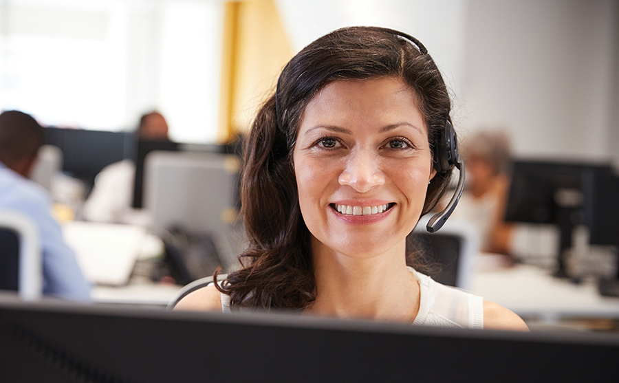 Woman smiling at the camera and working in a call centre